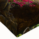 Close-up of a stretched canvas print depicting a vibrant village landscape with colorful houses, lush greenery, and a clear blue sky, perfect for home decor.