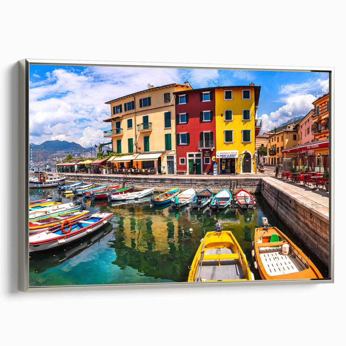 Framed canvas wall art showcasing a serene village landscape with vibrant colors, silver frame, and a modern design, perfect for enhancing home decor.
