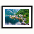 Framed wall art featuring a picturesque village landscape design with vibrant colors, set in a black frame with a white mat, ideal for home decor enhancement.
