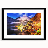 Framed wall art featuring a picturesque village landscape design, set in a sleek black frame with a white mat, perfect for home decor and interior styling.