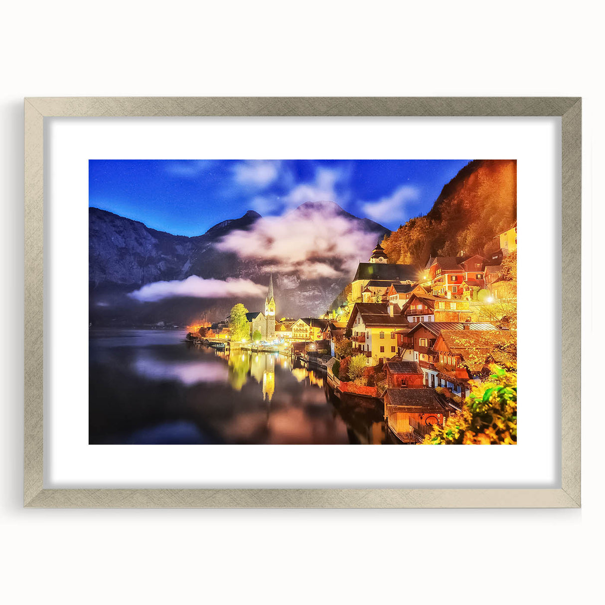 Framed landscape wall art featuring a serene village scene in soft pastel colors, accented by a silver frame and mat, ideal for home decor.