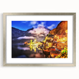 Framed landscape wall art featuring a serene village scene in soft pastel colors, accented by a silver frame and mat, ideal for home decor.