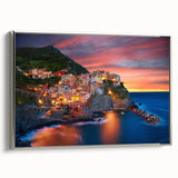 Framed canvas wall art showcasing a serene village landscape design with vibrant colors and intricate details, set in a sleek silver frame for an elegant display.