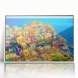 Framed wall art showcasing a serene village landscape design with vibrant colors, set in a sleek white frame, perfect for modern home decor.