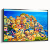 Framed canvas wall art showcasing a scenic village landscape design, featuring vibrant colors and intricate details, displayed from a side view against a neutral backdrop.