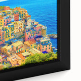 Framed canvas artwork showcasing a vibrant village landscape with lush greenery and colorful houses, perfect for home decor enthusiasts seeking unique wall art.