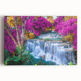 Stretched canvas wall art depicting a serene waterfall landscape, vibrant blue water cascading over rocks, surrounded by lush green foliage, perfect for home decor.