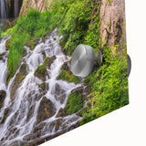 Close-up of a vibrant acrylic glass wall art piece showcasing a serene waterfall landscape, featuring lush greenery and cascading water, designed to enhance home decor.