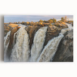 Stretched canvas artwork showcasing a serene landscape with a vibrant waterfall, surrounded by lush greenery and blue skies, ideal for home decor.