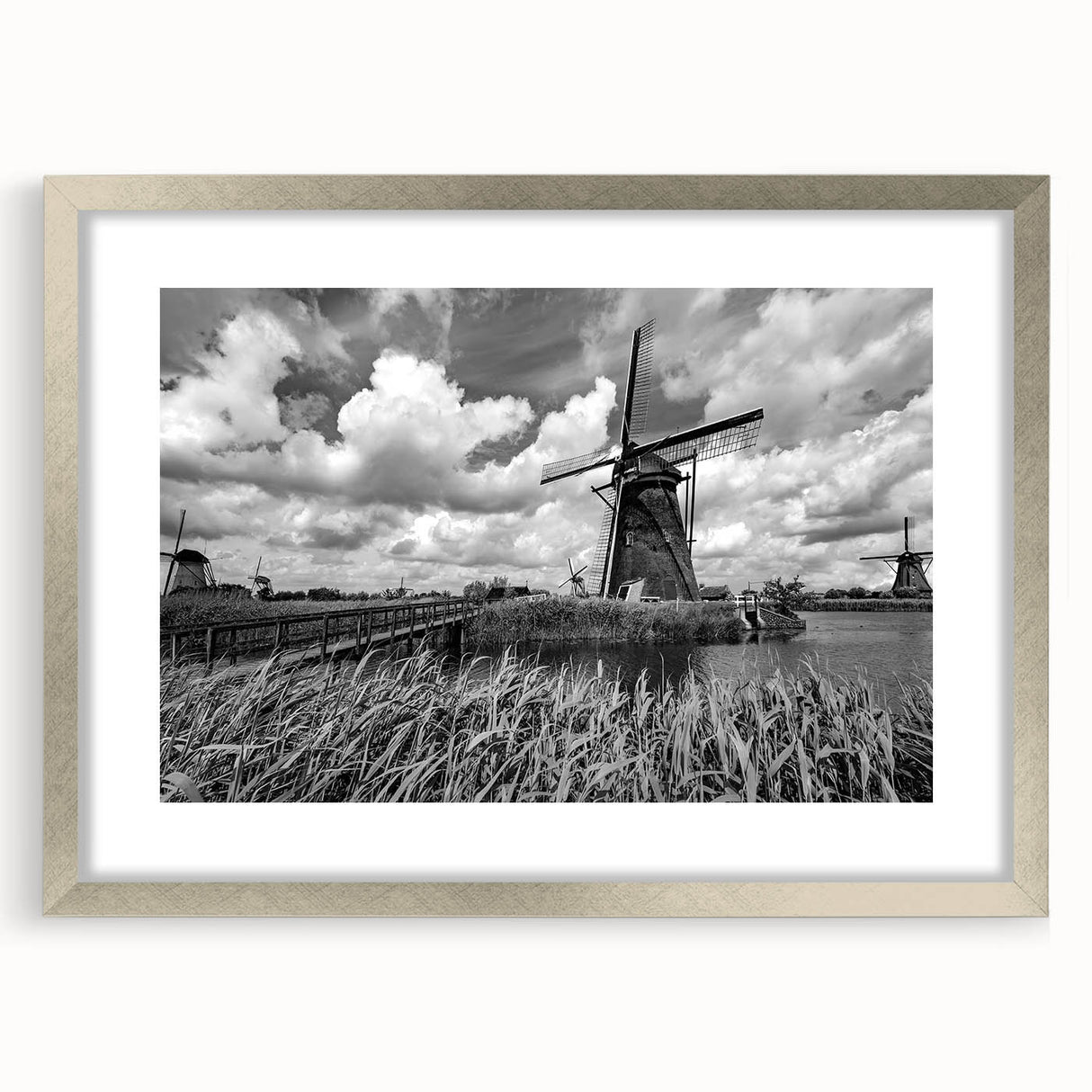 Framed wall art featuring a serene landscape with windmills, presented in a sleek silver frame with a mat, ideal for home decor and adding elegance to any space.