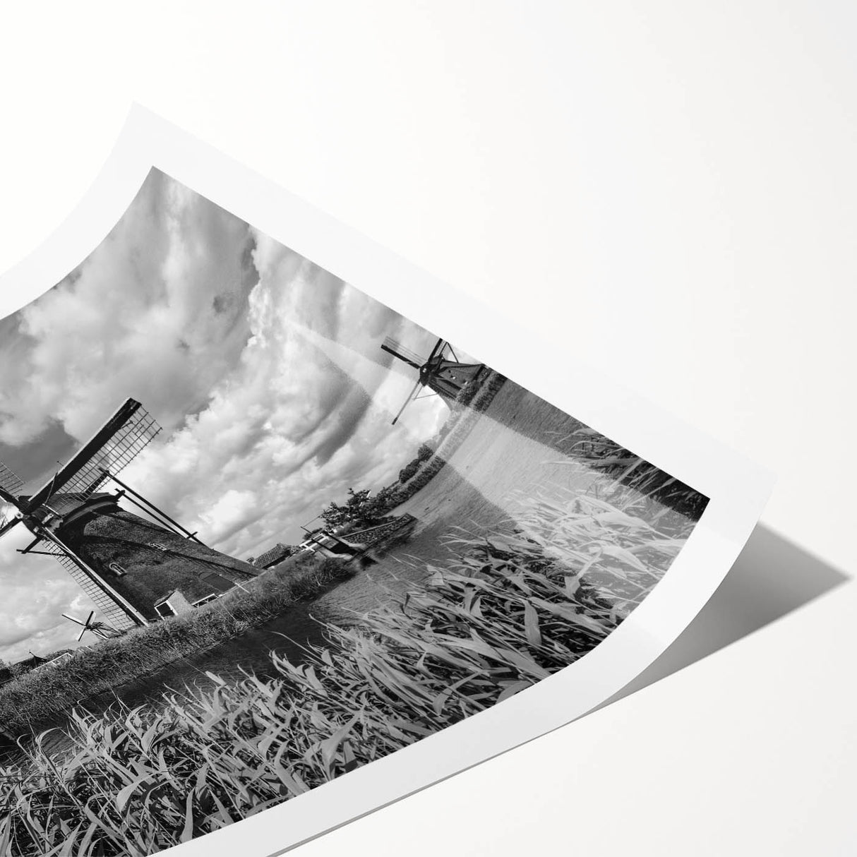 Rolled print of a serene landscape featuring iconic windmills against a vibrant sunset sky, ideal for home decor and wall art enthusiasts.