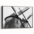 Framed canvas wall art depicting a serene landscape with windmills under a sunset sky, featuring a sleek black frame, ideal for modern home décor.