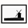 Framed wall art showcasing a serene landscape with windmills, featuring a sleek black frame and white matting, perfect for enhancing home decor aesthetics.