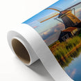 Rolled canvas artwork showcasing a vibrant landscape with windmills under a clear blue sky, perfect for enhancing home decor with a touch of nature.
