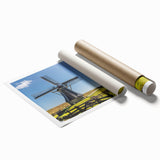 Rolled print artwork showcasing a serene landscape with windmills against a vibrant sunset sky, ideal for home decor or inspiring art collections.