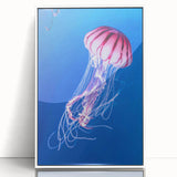 Framed wall art showcasing a vibrant jellyfish design in shades of blue and purple, set against a crisp white background, perfect for marine life enthusiasts and modern decor.