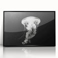 Framed wall art showcasing a vibrant jellyfish design in shades of blue and purple, set in a sleek black frame, perfect for marine-themed decor.