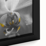 Close-up of a black framed canvas featuring a textured floral design in vibrant colors, ideal for living room decor.