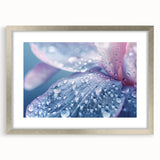 Textured art print of abstract ripples in muted blue and gray, framed in silver, ideal for bedroom decor.