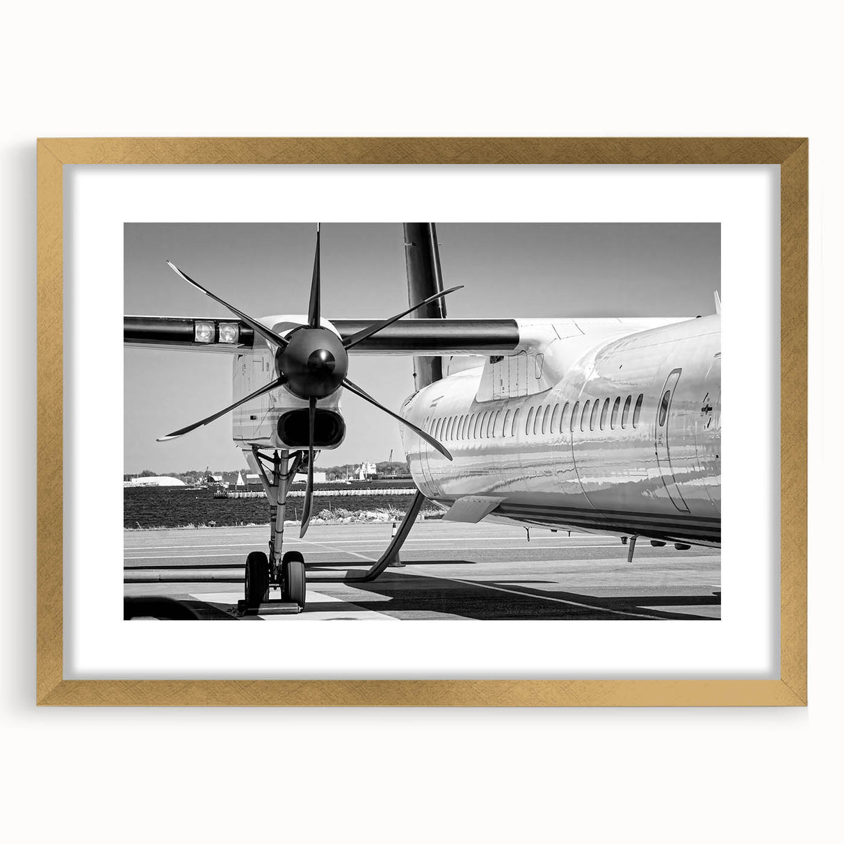 Abstract art print of an airplane in gold and black tones on a framed canvas, suitable for bedroom or dining room decor.