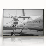 Mid-century modernist style airplane illustration in muted gray and blue tones on a silver-framed acrylic print.