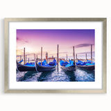 Abstract art print of a gondola on water, using cool blue and gray tones, framed in silver, suitable for dining room decor.
