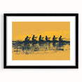 A vibrant abstract print of rowboats on water in bold colors on textured canvas, framed in black.