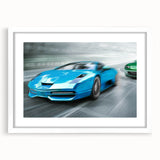 Abstract art print of race cars in motion, using muted gray and blue tones on a framed white mat.