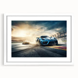 Abstract art print of race cars in motion, using blur effects in vibrant red and blue tones on a white framed canvas.