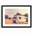 Abstract art print featuring a colorful, textured caravan in muted earth tones on a large framed canvas.